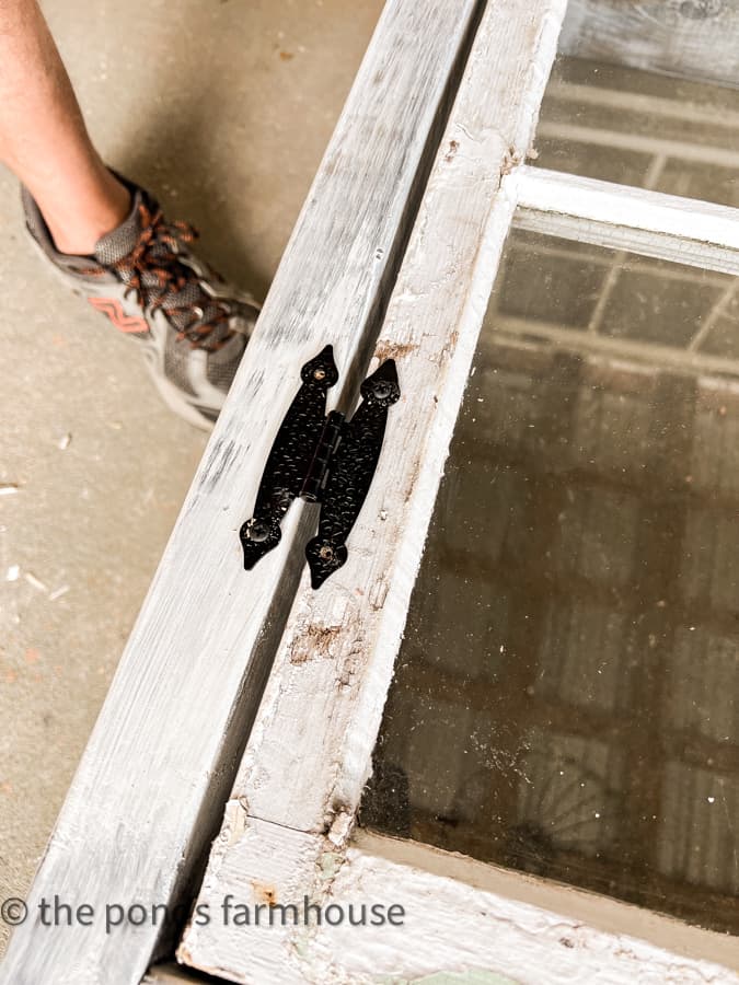 Hinges added to DIY outdoor kitchen cabinet.