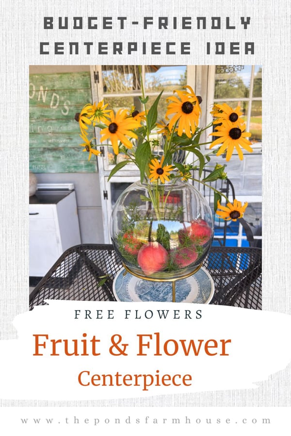 Fruit and flower arrangement in glass vessel.  