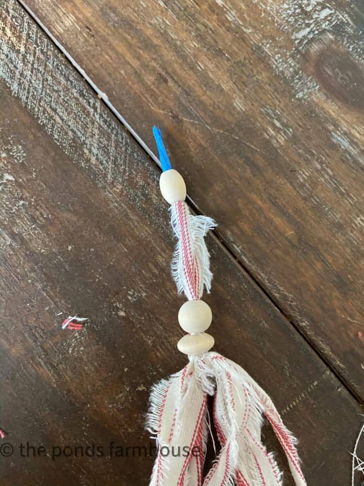 Add beads to ticking tassels