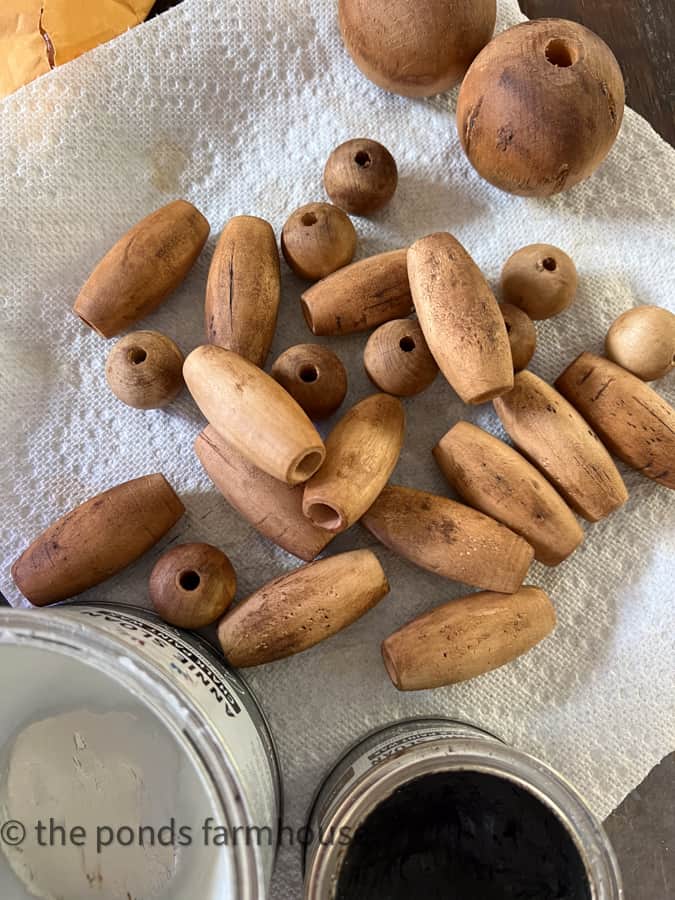 Distress the wood bead and add dark wax to create a faux fishing cork appearance for coastal garland