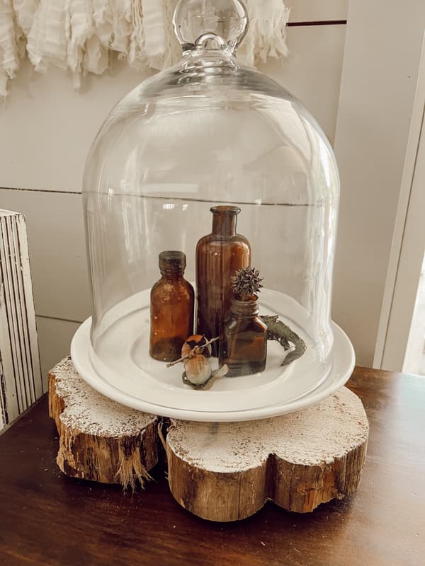 Amber Glass Bottles under a cloche for Rustic Fall Decorating Ideas.  Farmhouse, cottage and country style.