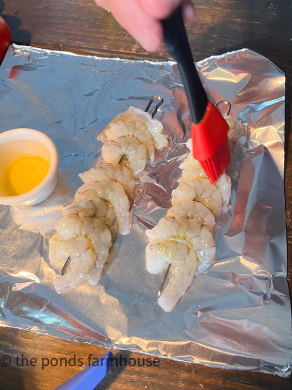 Add shrimp to skewers and brush with olive oil