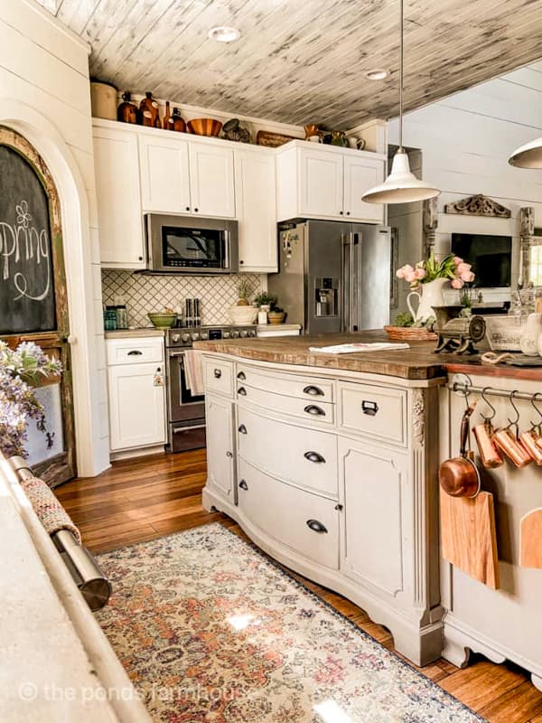 Farmhouse kitchen with DIY island and amber bottles on top of kitchen cabinets