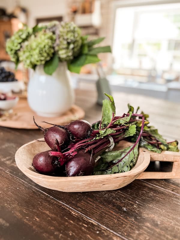 hand carved wooden bowl with beets on kitchen island. 