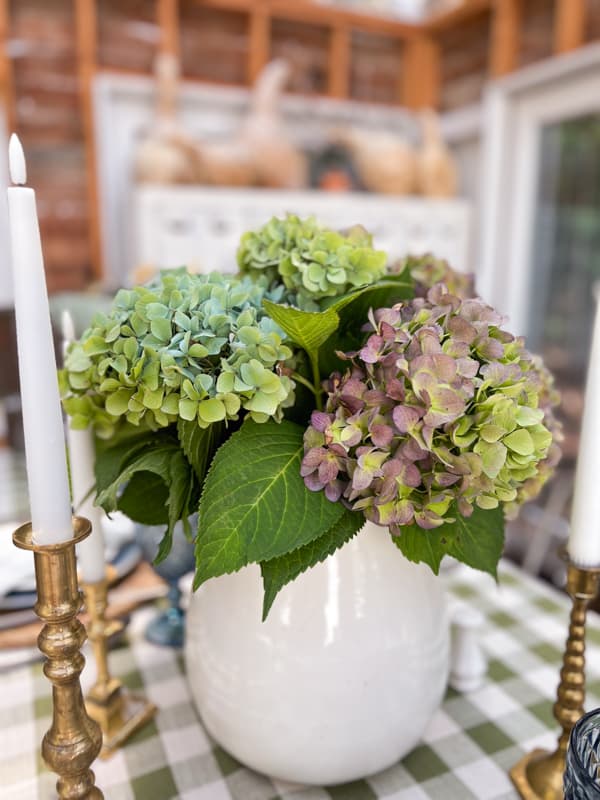 hydrangea flower arrangement in a white ironstone vessel for table centerpiece.