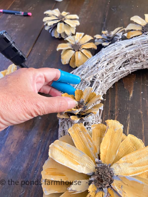 Press the sunflowers into the grapevine wreath and hold until dry.