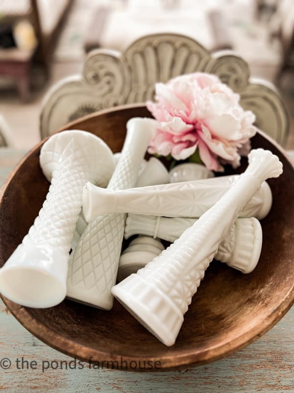 Vintage wooden bowl filled with milk glass vases