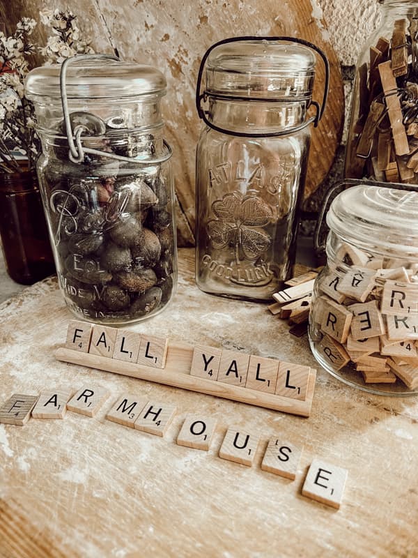 Clear old bottles filled with nuts and scrabble tiles for fall decorating.