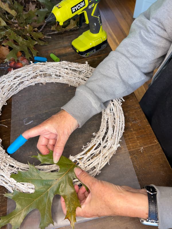 add leaves to grapevine wreath for eco-friendly autumn decorations