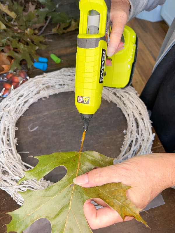 Add hot glue to oak leaves to make a budget-friendly wreath for autumn.