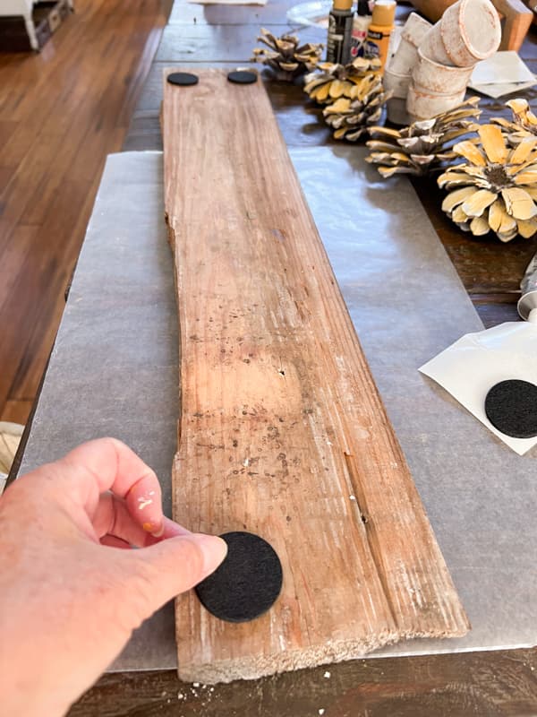 Use self-adhesive felt pads on the bottom of the wooden board to make centerpiece.