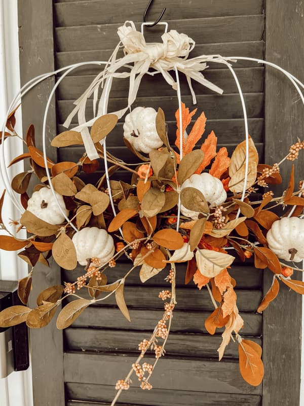 Dollar Tree Pumpkin Frame with faux fall stems for autumn wreath