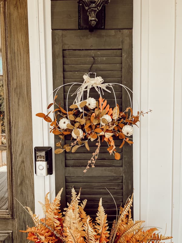 DIY pumpkin wreath form with raffia ribbon. on black shuttter