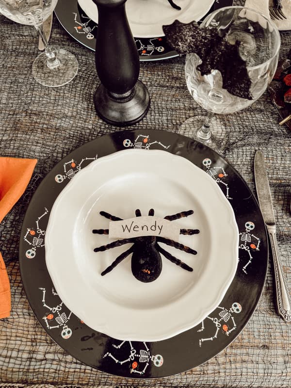 Dollar Tree Spider place card holder in plate center with spooky charger plates for halloween dinner party