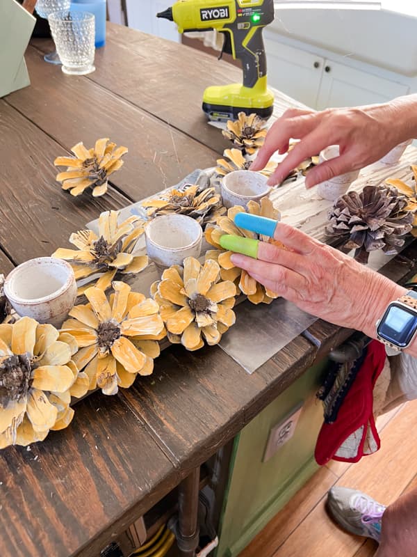 Surround the clay pots with DIY Pinecone flowers for a Sunflower Centerpiece made with pinecones.  