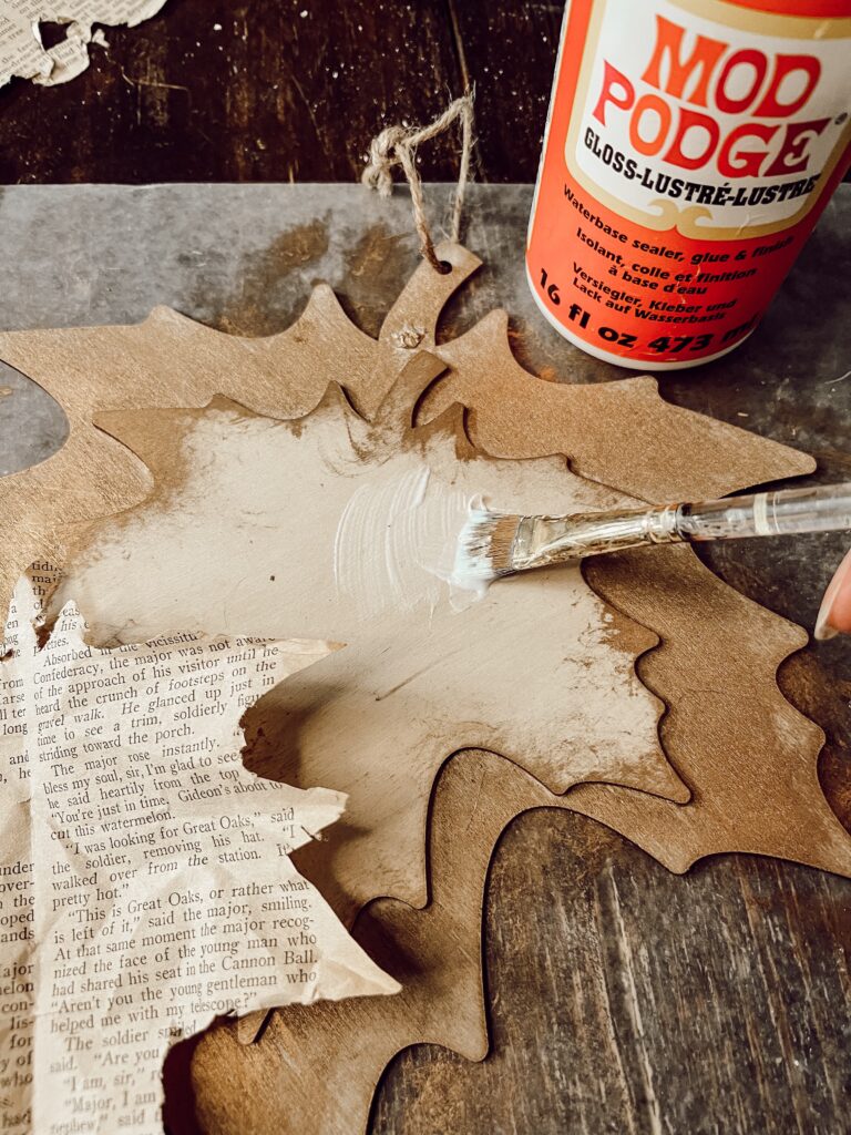 Add mod podge to decoupage the old book page leaf for a rustic fall decoration. 