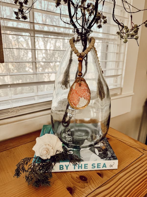 Make a DIY Oyster Shell Christmas Ornament charm to tie around a large bottle for a cottage core style holiday.