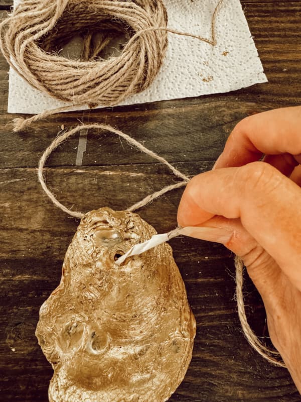 Add tape to the ends of the jute twine to thread them through the shell hole.  
