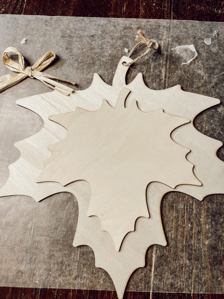 Remove bow from Dollar Tree Woodcraft Leaf for Fall Leaf Project that's budget-friendly.