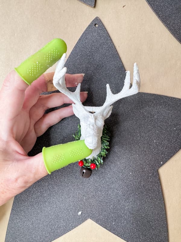 Add deer head Dollar Tree ornaments to the star wood cutouts for unique holiday decor.