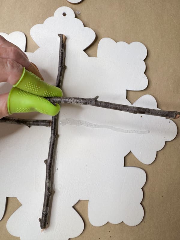 add twigs to wood snowflake with hot glue.