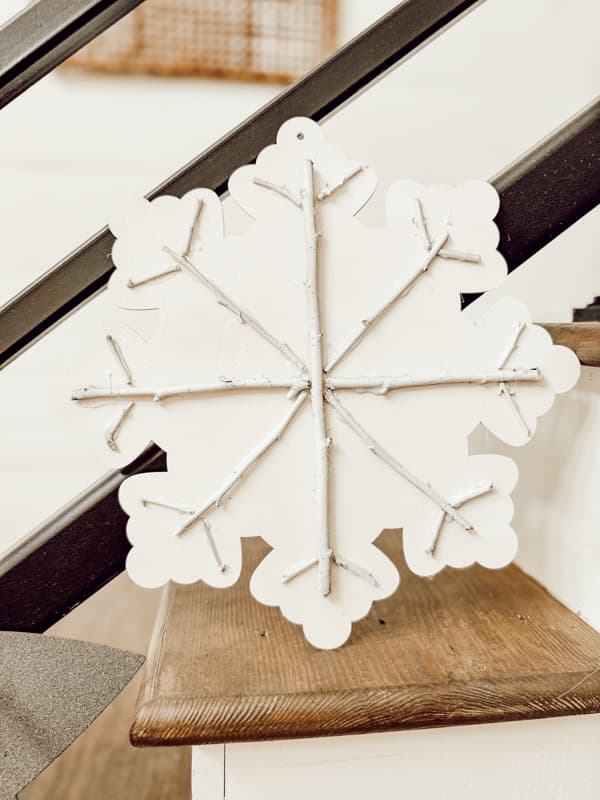 Snowflake Wood Cutout from Dollar Tree with foraged twigs to enhance oversized Christmas ornaments