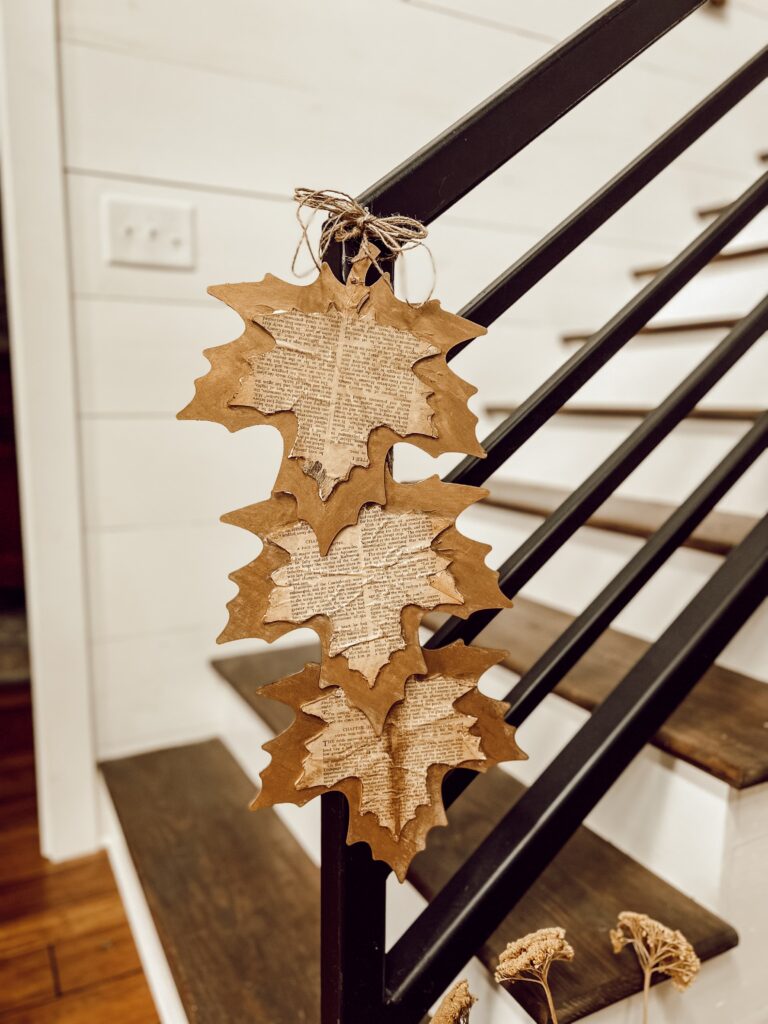 Hang DIY FAll Leaves made with old book pages and on Banister