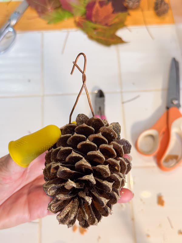 Add copper wire to create a place card holder on the pinecone