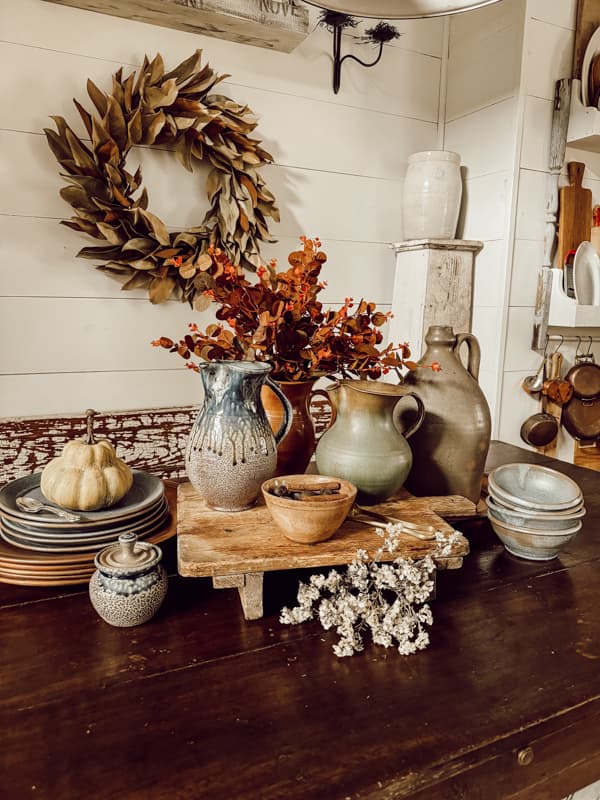 Farm style table with rustic vintage and new pottery for styling vintage in a modern farmhouse