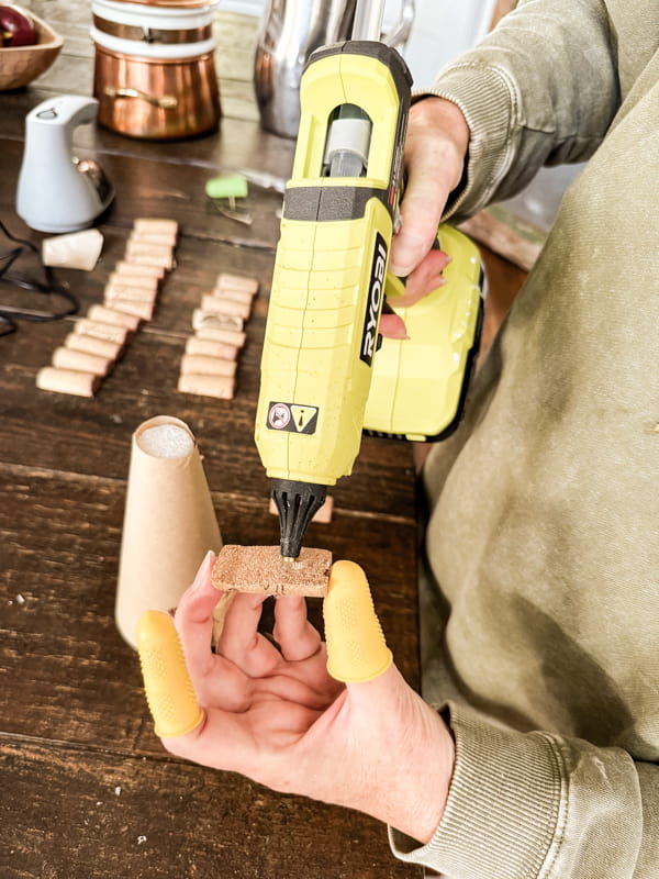 Add hot glue to flat side of corks