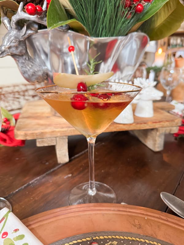 Christmas Cranberry Pear Martini. Raised bread board with silver deer platter on farmhouse table.