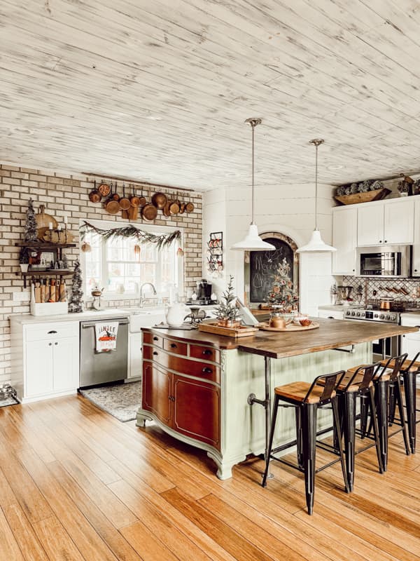 Textured shiplaps wall with brick create a cozy vintage Christmas Kitchen for a curated home.