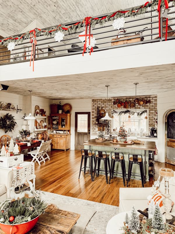  Curated Copper Collection on brick wall in kitchen with DIY Vintage Island and industrial bar stools for a curated home.