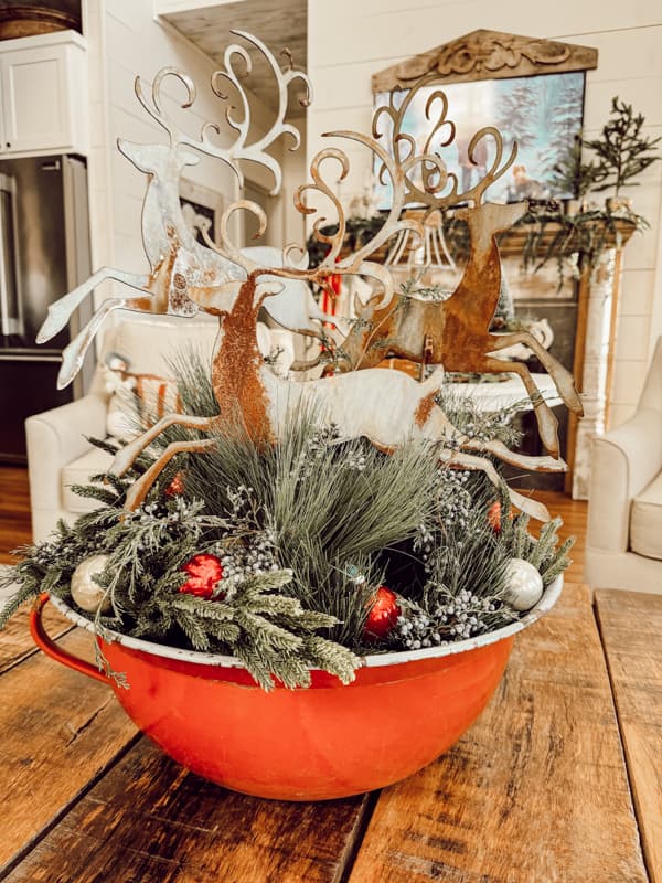 Antique Red enamelware bowl as coffee table centerpiece with metal reindeers, evergreen and vintage ornaments. 