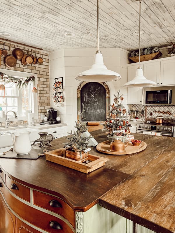 Vintage DIY Kitchen Island filled with Mini-trees decorated with dried orange slices for a curated cottage core style of Christmas Decorating.  