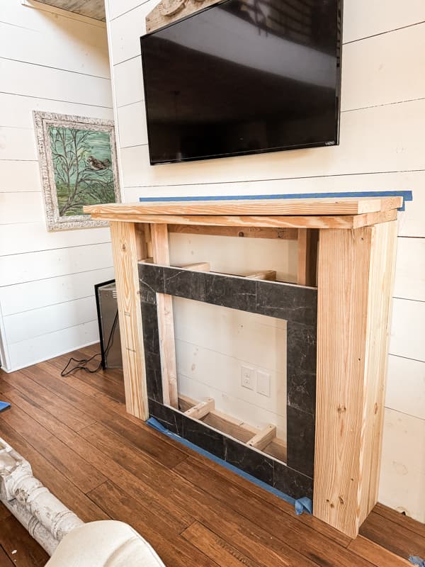 Add wood to surround the frame work of the DIY Shabby Chic Faux Mantel.