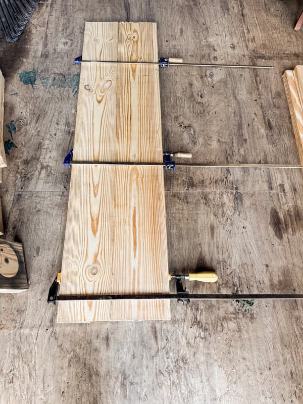 Clamp boards together to form the top of the DIY mantel