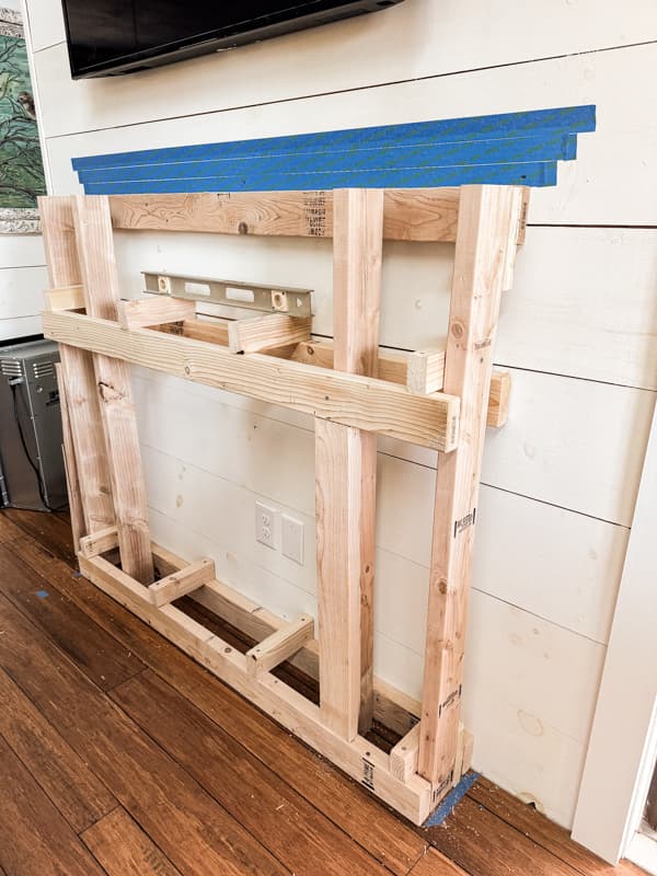 Build a frame with 2x4's to encase the electric fireplace.