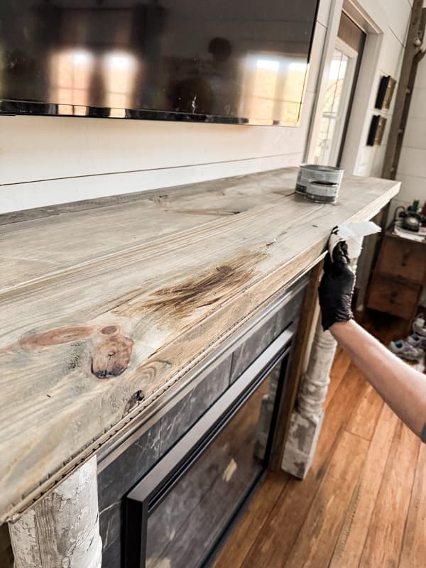Use dark wax to further age the wood on the DIY mantel.