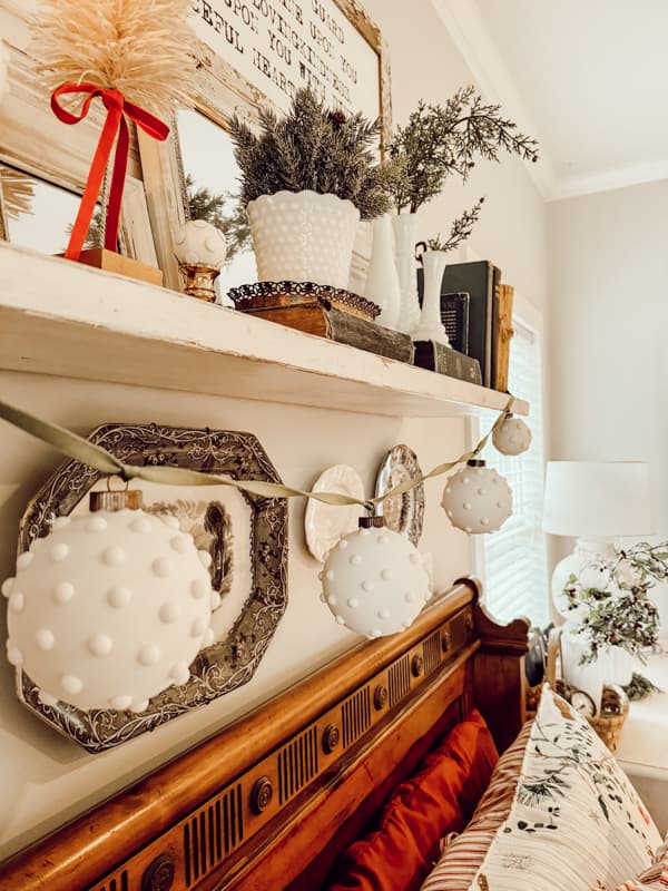 Hang Easy DIY Hobnail Milk glass ornaments on a ribbon over mantel for Christmas decorating.