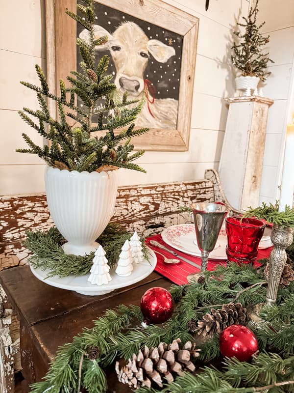 Vintage Milk glass cake stand with a vase holding a mini Christmas tree for Christmas Farmhouse Decorating.