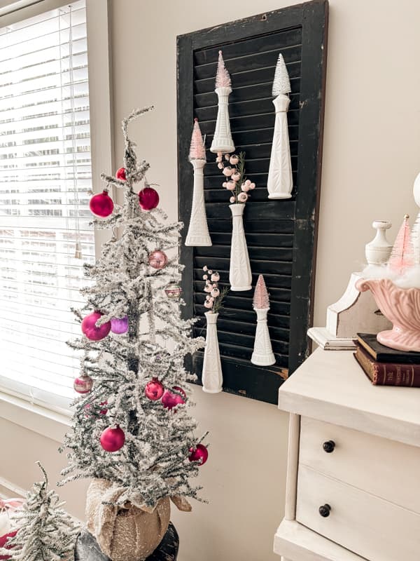 Pink Christmas Decorations with vintage shiny brite ornaments on a flocked tree and vintage milk glass vases