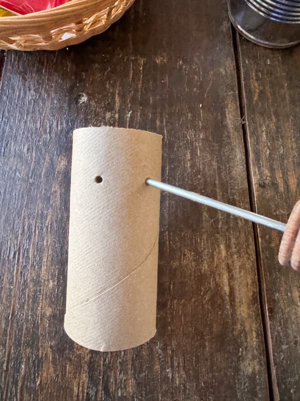 Punch a hole in the toilet paper roll with an ice pick. 