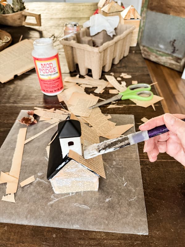 paint Christmas Village Roof with mod podge and add book pages to cover. 