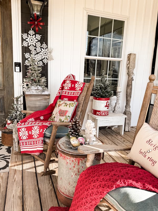 Cozy Christmas Porch with red throw blankets and Kennedy Rockers with snowflakes and flocked trees