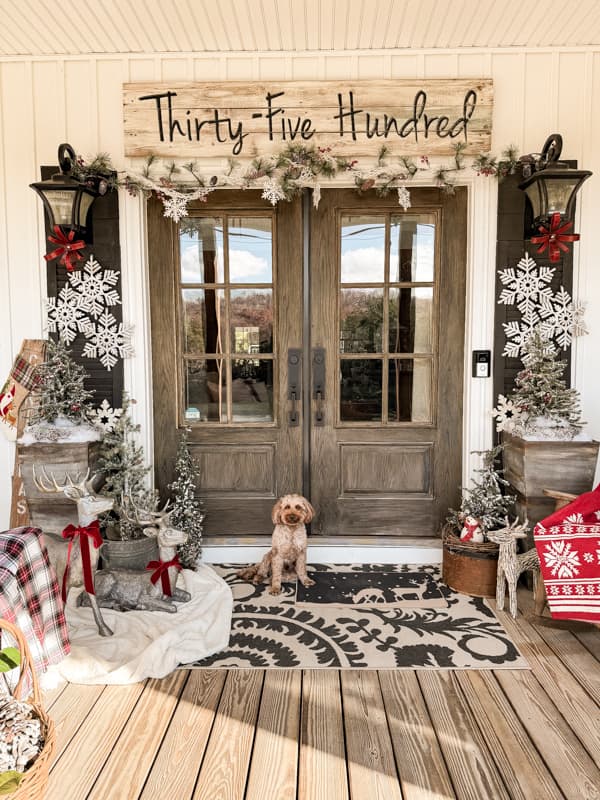 Cozy Christmas Porch - country farmhouse porch decorated with a Winter Wonderland theme.  Rudy, mini-golden doodle on porch.