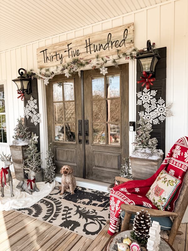 Front porch decorated for Christmas with french doors, reindeer, and snowflakes