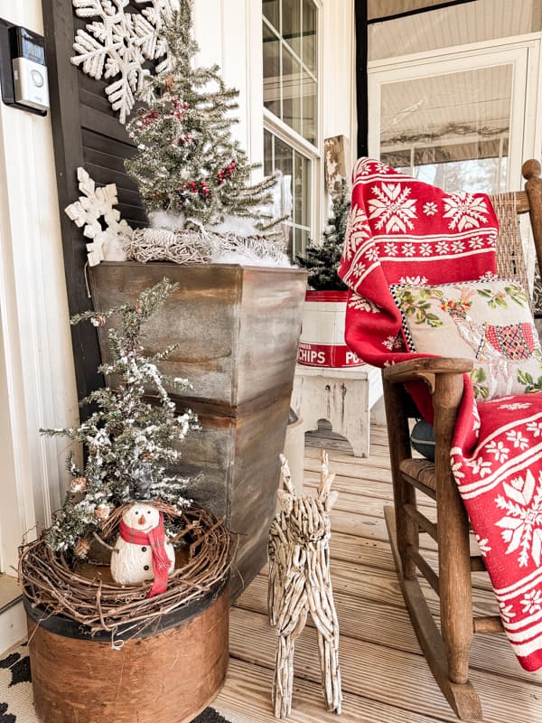 DIY planters with flocked Christmas trees and red throw blanket on Kennedy Rocker with reindeers.