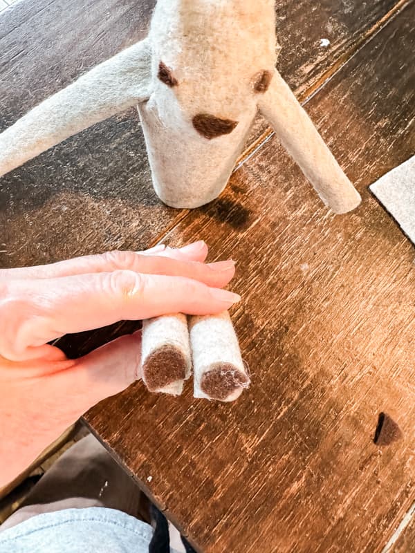 attach brown felt fabric to ends of deer legs for hoves.