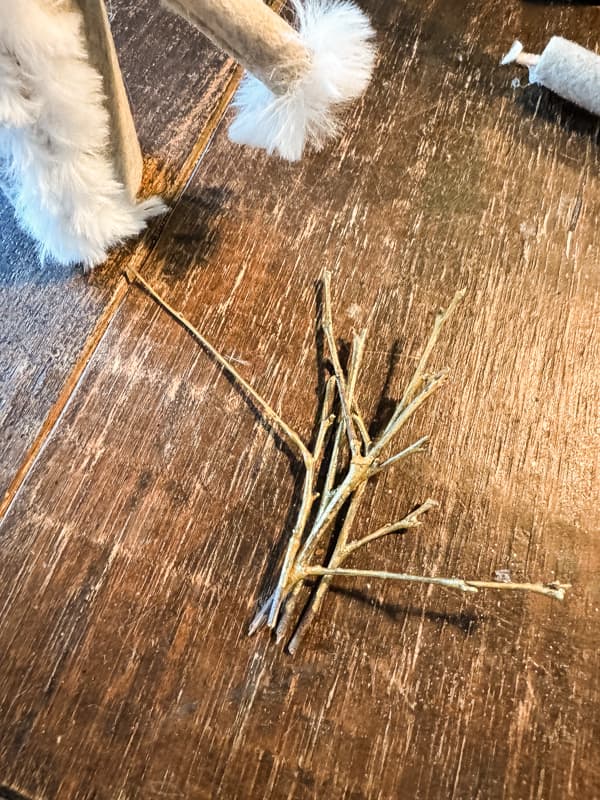 Paint twigs gold for DIY antlers.